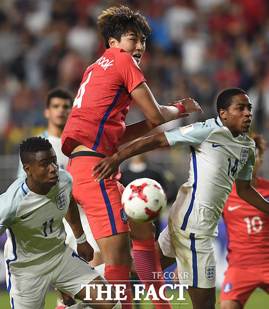 한국 정태욱이 잉글랜드 수비수에 앞서 헤딩슛을 하고 있다.