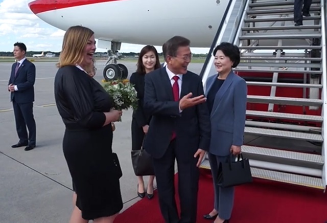 6일(현지 시각) G20 정상회의가 열리는 독일 함부르크 헬무트 슈미트 공항에 도착한 문재인 대통령이독일 측 관계자가 들고나온 꽃다발을 받으려다 김정숙 여사의 몫인 걸 알고 멋쩍어하며 크게 웃고 있다./청와대 페이스북