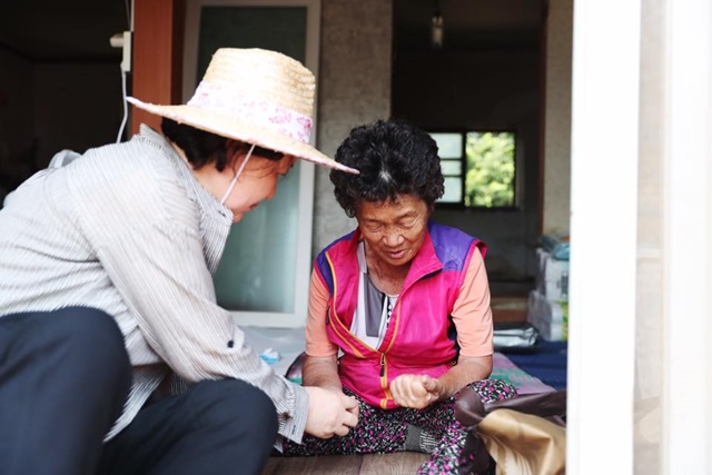 김정숙 여사가 마을 주민의 집을 방문해 손을 잡고 위로하고 있다./청와대 페이스북