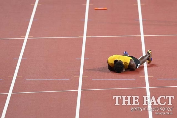 우사인 볼트가 13일(한국시간) 영국 런던에서 벌어진 세계육상선수권대회 남자 400m 계주에서 자메이카의 마지막 주자로 나섰으나 부상으로 트랙 위에 넘어져 있다. /런던=게티이미지