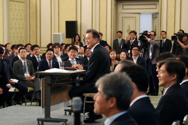 문재인 대통령이 취재진의 질문을 들으며 미소 짓고 있다./청와대 제공