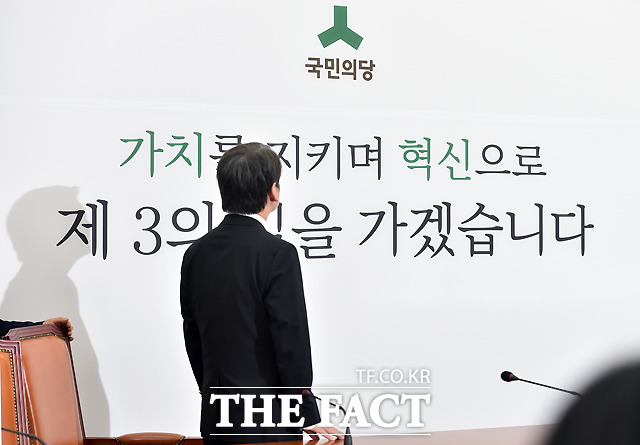 벽에 걸린 현수막 문구를 바라보는 안철수 신임 당대표