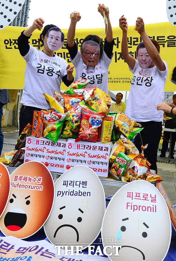 동물권 단체 케어의 계란범벅 과자는 먹기 싫어요 기자회견이 6일 오후 서울 광화문 광장 이순신 동상 앞에서 열린 가운데 참가자들이 과자 위로 날계란을 깨뜨리는 퍼포먼스를 하고 있다.