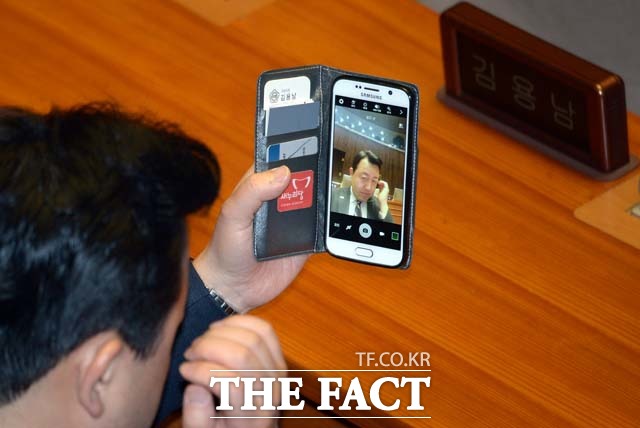 김용남 전 새누리당 의원은 지난해 2월19일 오전 서울 여의도 국회에서 열린 경제분야 대정부질문에 참석해 회의 시작을 앞두고 휴대폰을 거울 삼아 매무새를 갖추고 있다. /국회=임영무 기자