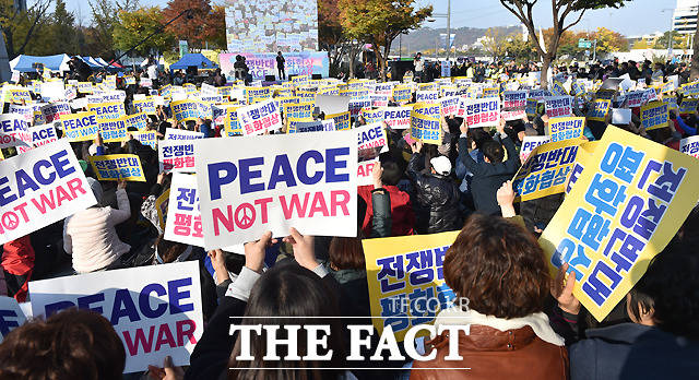 트럼프 미국 대통령이 방한을 이틀 앞둔 5일 오후 서울 광화문 세종로 공원에서 시민평화행동 전쟁반대 평화협상 PEACE NOT WAR 집회가 열린 가운데,  참가자들이 전쟁을 반대하는 피켓을 들어보이고 있다./이새롬 기자