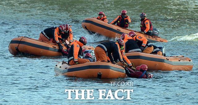 고무보트를 탄 구조대가 한강에 빠진 탑승객을 구하고 있다.