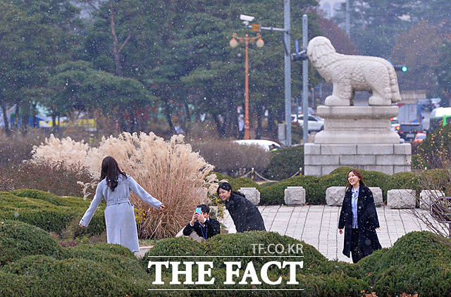 서울에 첫눈이 내린 20일 오후 서울 여의도 국회에서 시민들이 첫눈을 배경으로 시민들이 사진을 찍고 있다. /문병희 기자