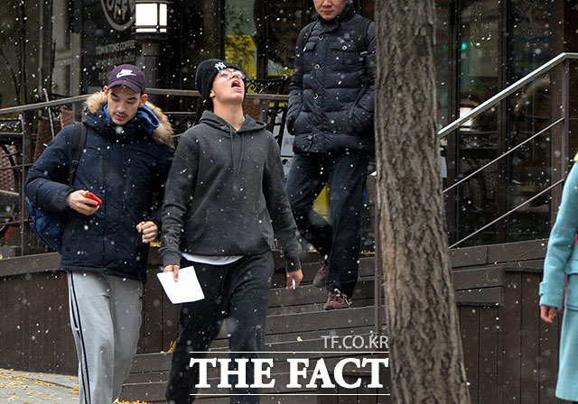 첫눈이 내린 20일 오후 서울 서초구 반포동 일대에서 길을 지나던 한 외국인이 눈을 맞으며 즐거워하고 있다. /이효균 기자