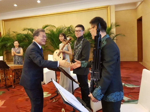 15일 천민얼 충칭시 서기와 오찬자리에서 중국 전통악기 연주자들에게 다가가 악수를 청하는 문재인 대통령./청와대 페이스북