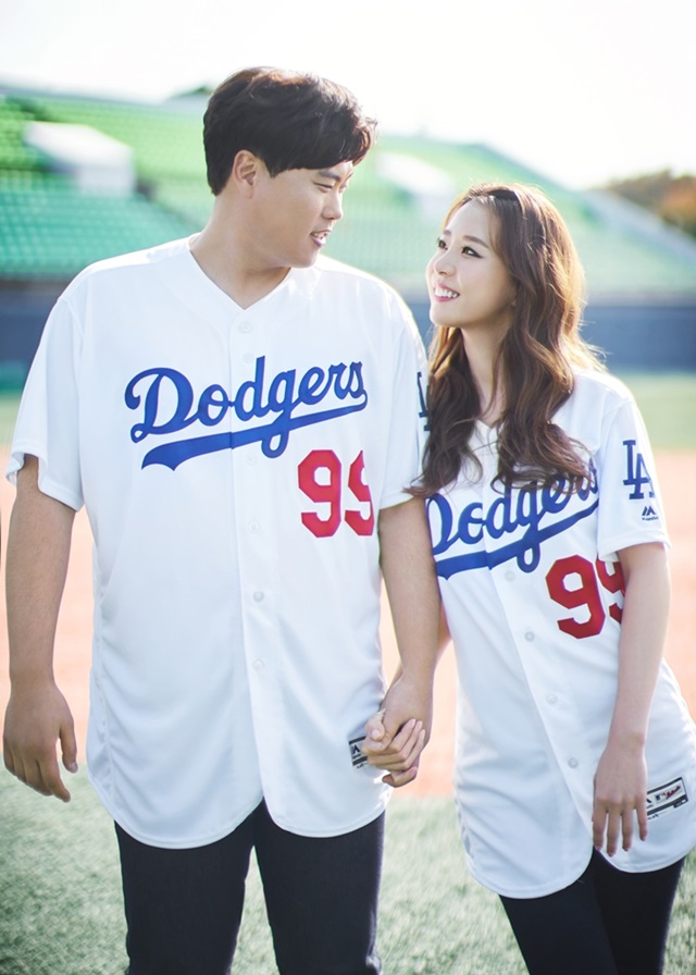 류현진(왼쪽) 배지현 커플이 LA다저스 유니폼을 입고 미소 짓고 있다. /아이패밀리