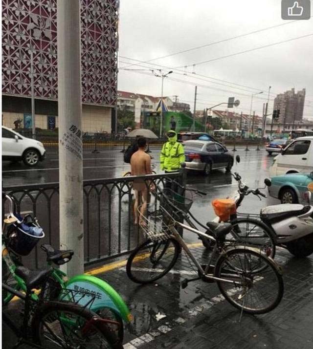 나체의 한 남성이 비오는 도로 위에서 공안과 이야기를 나누고 있다. /온라인 커뮤니티