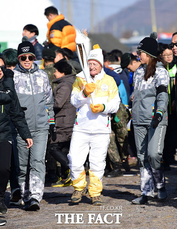 한국전쟁 참전용사 클로드 P.E 샤를랭 씨가 성화 봉송을 하고 있다.