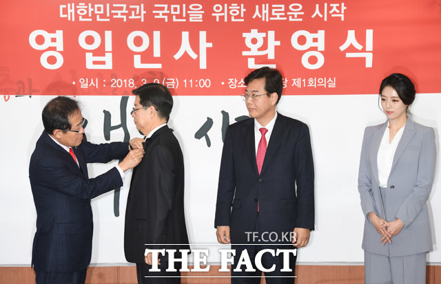 홍준표 대표가 길환영 전 KBS사장에게 태극기 배지를 달아주고 있다. /배정한 기자