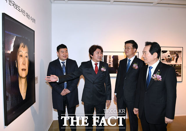 정세균 국회의장(오른쪽)이 이동희 한국사진기자협회장의 안내로 대상을 수상한 박근혜 전 대통령의 사진을 살펴보고 있다.