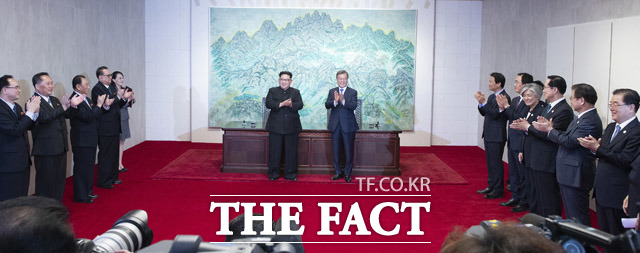 문재인 대통령과 김정은 국무위위원장(왼쪽)이  판문점 선언문에 사인한 뒤 서로 박수를 치고 있다.