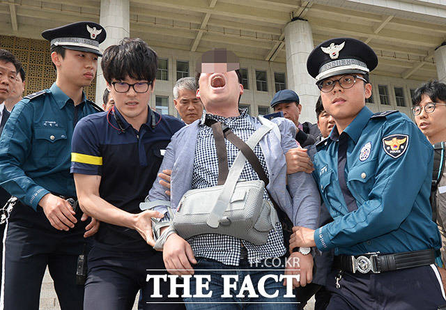 한국당은 김 원내대표를 폭행한 김 모 씨가 계획적으로 범행을 저질렀다고 보았다. 성일종 의원은 홍준표 대표도 테러하려고 했다고 밝혔다. 사진은 5일 김 원내대표를 폭행한 김 씨가 경찰에 연행되던 당시.