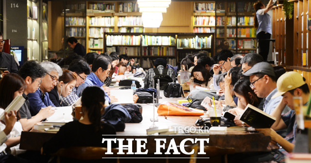 서울의 한낮 기온이 27도까지 오른 15일 오후 서울 종로구 교보문고에서 시민들이 책을 보며 더위를 식히고 있다. / 이선화 기자