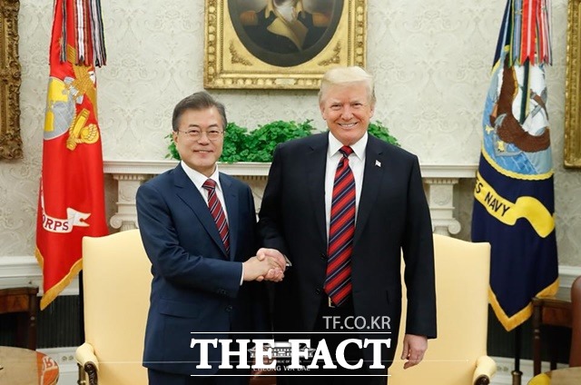 문재인(왼쪽) 대통령이 트럼프 대통령과 손을 마주잡으며 미소 짓고 있다./청와대 페이스북