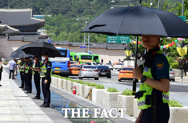 광화문광장에서 경계근무 중인 경찰들도 마른하늘에 우산을 펼쳤다.