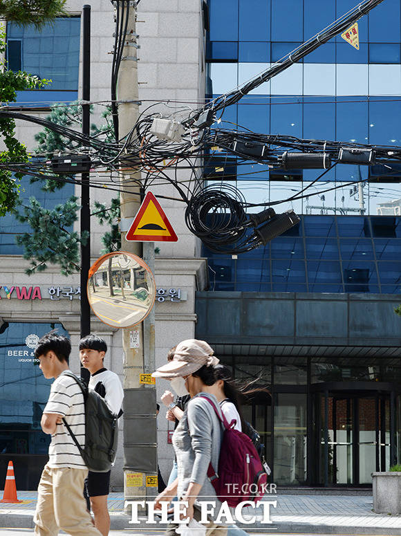 서울 서대문구 북아현동 거리, 걸어다니는 대학생들 위로 아슬아슬 매달린 전선과 케이블.