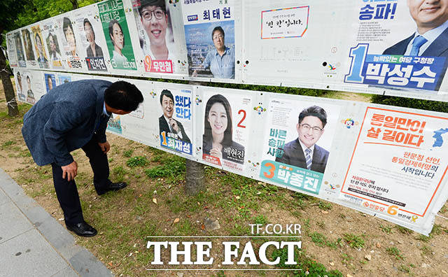 4일 오후 서울 송파구 잠실동 한 거리에 부착된 송파구 을 국회의원 재보궐선거 벽보를 한 시민이 보고 있다. /김세정 기자