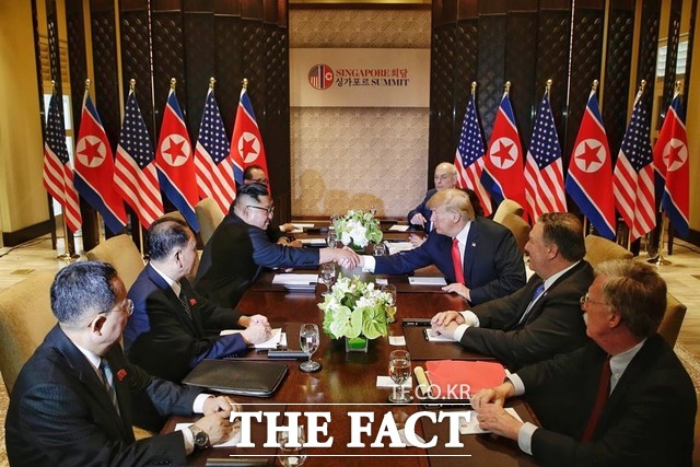 김정은 북한 국무위원장과 도널드 트럼프 미국 대통령이 12일 싱가포르 카펠라 호텔에서 정상회담을 갖고 있다. 사진은 확대회담에서 악수하는 두 정상. /싱가포르 통신정보부 제공