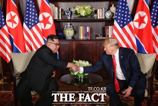김정은 위원장(왼쪽)과 트럼프 미대통령이 회담에 앞서 악수를 나누고 있다./싱가포르 통신정보부