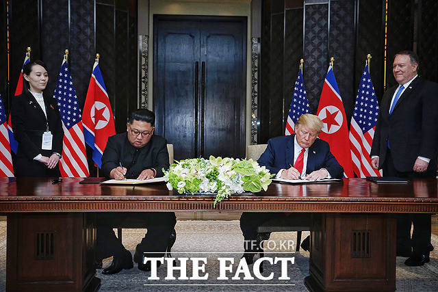 김정은 북한 국무위원장(왼쪽)과 도널드 트럼프 미국 대통령이 12일 싱가포르 센토사섬 카펠라호텔에서 열린 북미정상회담 공동합의문 서명식에서 사인을 하고 있다. / 싱가포르 통신정보부
