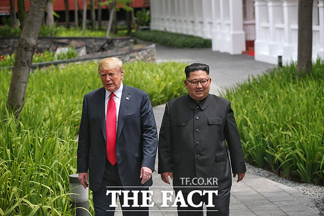 김정은 북한 국무위원장과 도널드 트럼프 미국 대통령(왼쪽)이 12일 싱가포르 센토사섬 카펠라호텔에서 열린 북미정상회담 업무오찬을 마친 뒤 호텔 내부 정원을 산책하고 있다. / 싱가포르 통신정보부