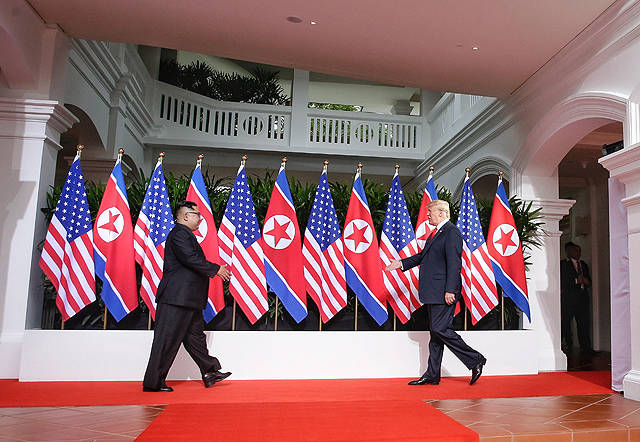 김정은 북한 국무위원장(왼쪽)과 트럼프 미국 대통령이 12일 오전 싱가포르 센토사섬 카펠라호텔에서 정전 65년 만에 열린 북미정상회담에 참석해 악수를 하고 있다. /싱가포르 정보통신부
