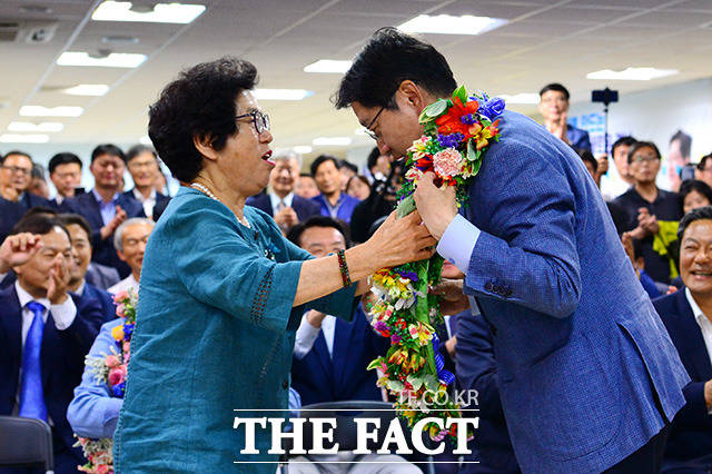 김경수 더불어민주당 경남도지사 후보(오른쪽)가 14일 새벽 경남 창원시 의창구에 위치한 자신의 선거 사무실에서 어머니 이순자 씨에게 꽃 목걸이를 선물 받고 있다. /창원=남용희 기자