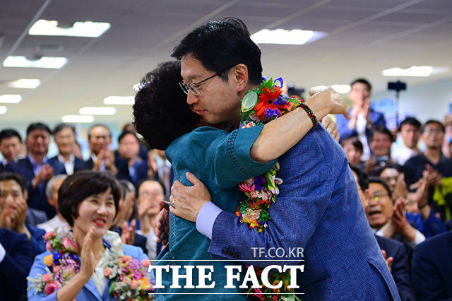 김경수 더불어민주당 경남도지사 후보(오른쪽)가 14일 새벽 경남 창원시 의창구에 위치한 자신의 선거 사무실에서 어머니 이순자 씨에게 꽃 목걸이를 선물 받고 있다. /창원=남용희 기자