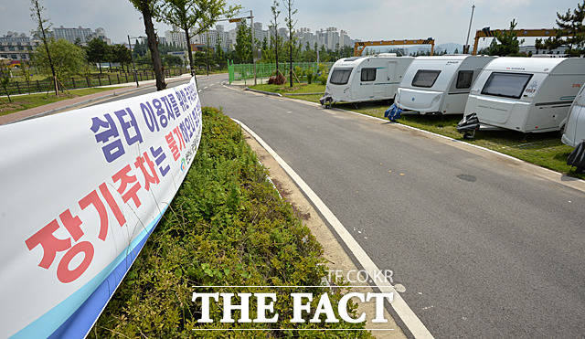 무료 주차장 이용하는 얌체 캠핑카 - 충남 천안시 신방공원 내에 장기주차를 금지하는 현수막이 걸려 있지만 바로 앞에 수대의 캠핑카가 버젓이 주차돼 있다. /문병희 기자
