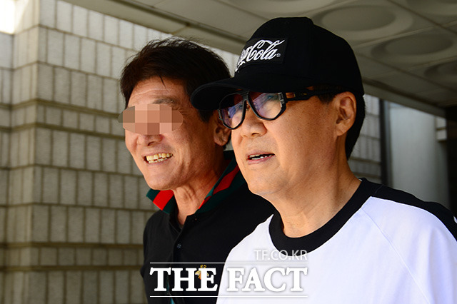 그림 대작 사기 의혹을 받고 있는 가수 조영남(오른쪽)이 13일 오후 서울 서초구 서울중앙지방법원에서 열린 항소심 2차 공판을 마치고 법원을 나서며 옅은 미소를 짓고 있다. /남용희 기자