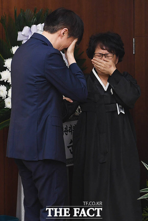 조국 청와대 민정수석(왼쪽)이 24일 오후 서울 서대문구 연세대 세브란스병원 장례식장에 마련된 고 노회찬 정의당 원내대표의 빈소에서 노 원내대표의 부인 김지선 씨의 손을 잡은채 오열하고 있다. / 배정한 기자