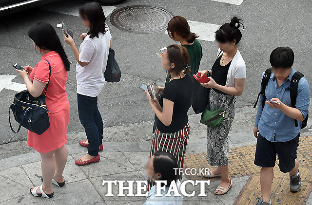 이동통신사들이 최근 내놓은 새로운 통신 요금제에 대한 관심이 뜨겁다. 사진은 거리에서 스마트폰을 사용하고 있는 서울 시민들. /더팩트 DB