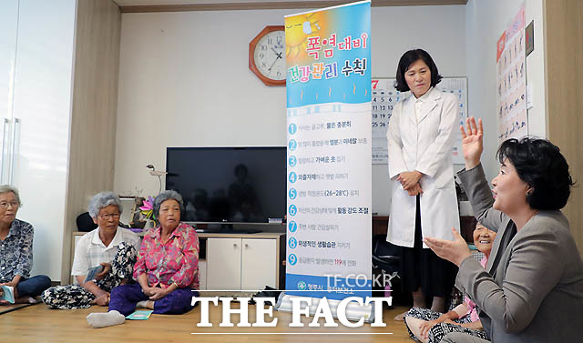 김 여사가 보건소 방문 간호사의 폭염 대비 안전 수칙에 대해 마을 어르신들과 함께 설명을 듣고 있다./청와대 제공