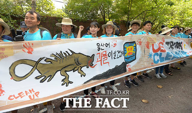 한반도 평화와 통일을 위한 1박 2일 행동이 29일 오전 서울 용산구 미군기지 앞에서 용산 미군기지 담벼락에 평화를 그리자!-100인의 평화 담벼락 행사를 연 가운데 참가자들이 직접 그린 현수막을 들고 서 있다. /김세정 기자