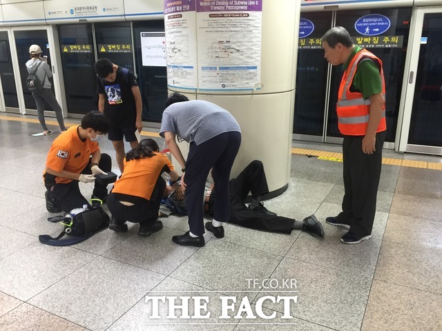 서울 낮 최고기온이 38도에 육박한 3일 서울 지하철 이용객들은 숨쉬기 힘들 정도의 찜통 열기에 불편을 호소했다. 사진은 이날 승강장 바닥에 누워 고통스러워하는 시민과 그를 돕는 119구급대원 모습. /임현경 인턴기자