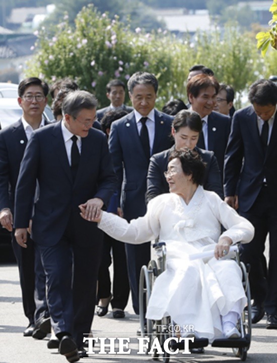 문재인 대통령은 여성 독립운동가 발굴과 의미를 강조하며 여성들의 활동을 부각시키고 있지만 다른 한편에서는 워마드 회원들의 탄핵 시위를 맞고 있다. 사진은 문 대통령이 14일 일본군 위안부 피해자 이용수 할머니의 손을 잡고 위안부 기림의 날에 참석하는 모습./청와대 제공