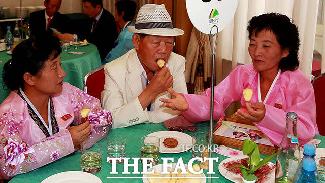 남측 최학진(80) 할아버지(가운데)가 북측 조카 최용순, 최용복씨와 과일을 먹으며 이야기를 나누고 있다.