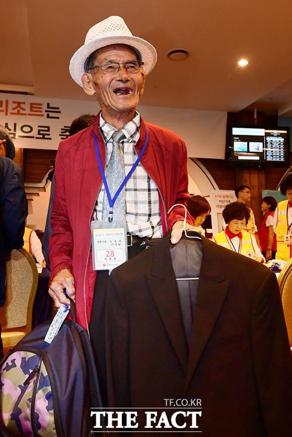 이호길(93) 할아버지가 북측 동생 리준성(86)씨를 만날 때 입을 정장을 들어보이며 밝게 웃고 있다.