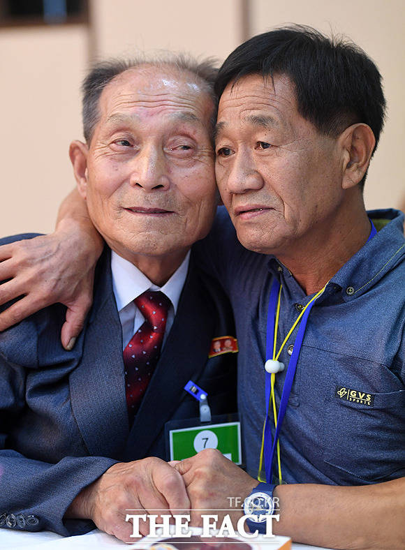 남측 김유철(58·오른쪽)씨가 북측 사촌형 김유성(82)씨와 손을 맞잡고 있다.