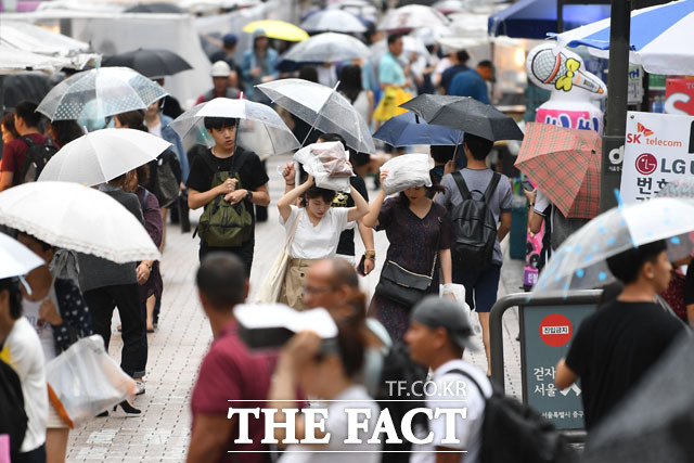 서울 낮기온 28도로 선선한 날씨를 보인 26일 오후 서울 명동거리에 약한 빗줄기가 내려 관광객과 시민들이 걸음을 재촉하고 있다./남윤호 기자