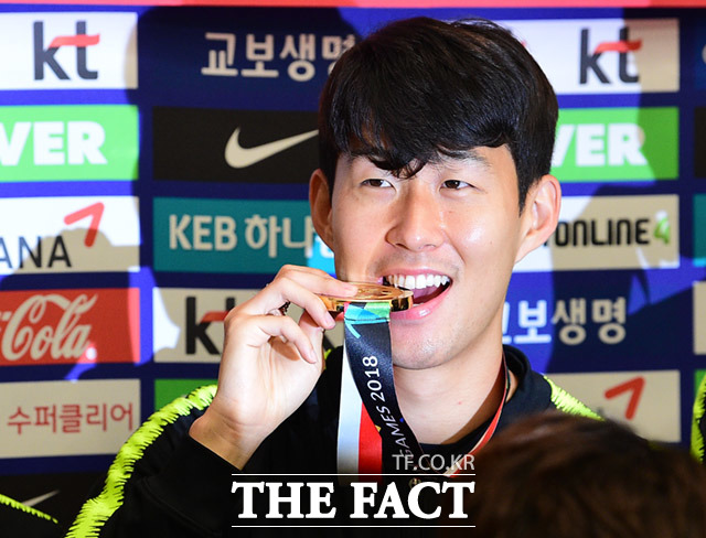 손흥민 선수가 3일 오전 인천국제공항으로 귀국 후 가진 대표팀 해단식에 참석해 금메달을 물고 포즈를 취하고 있다. /임세준 기자