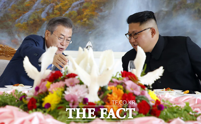 문재인 대통령(왼쪽)과 김정은 국무위원장이 평양소주를 보며 얘기를 나누고 있다.