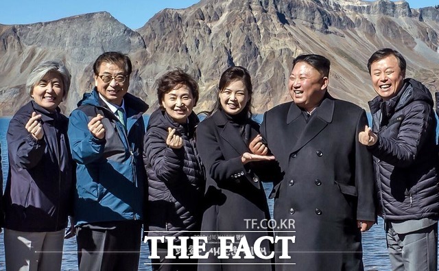 김정은 북한 국무위원장이 지난 20일 백두산 천지에서 남측 특별수행단과 사진을 찍는 가운데 손가락 하트 포즈를 취하며 웃고 있다. /청와대 제공