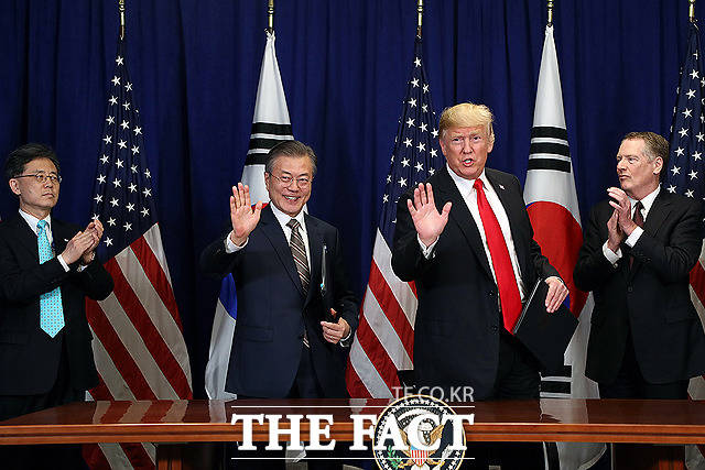 한-미 FTA 관련 서명을 마친 뒤 문재인 대통령(왼쪽)과 도널드 트럼프 미국 대통령이 손을 흔들고 있다.
