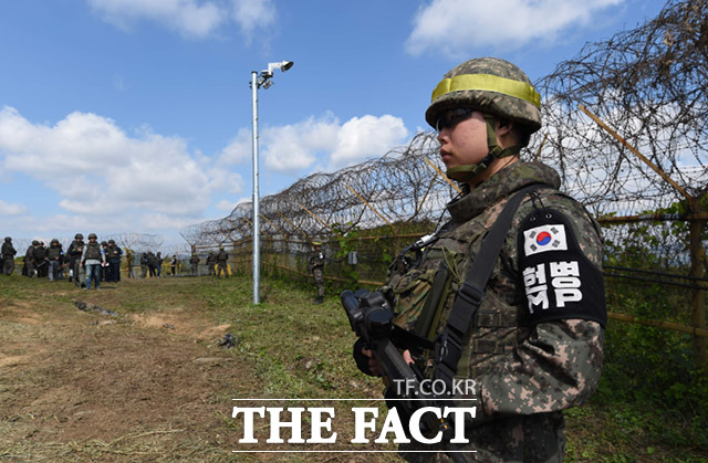 지뢰작업이 진행중인 가운데 한 장병이 현장 주변에서 경계근무를 서고 있다.