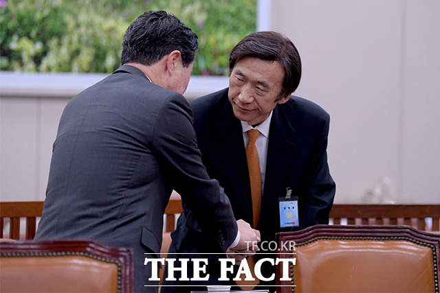 유기준 자유한국당 의원(왼쪽)과 악수하는 윤 전 장관